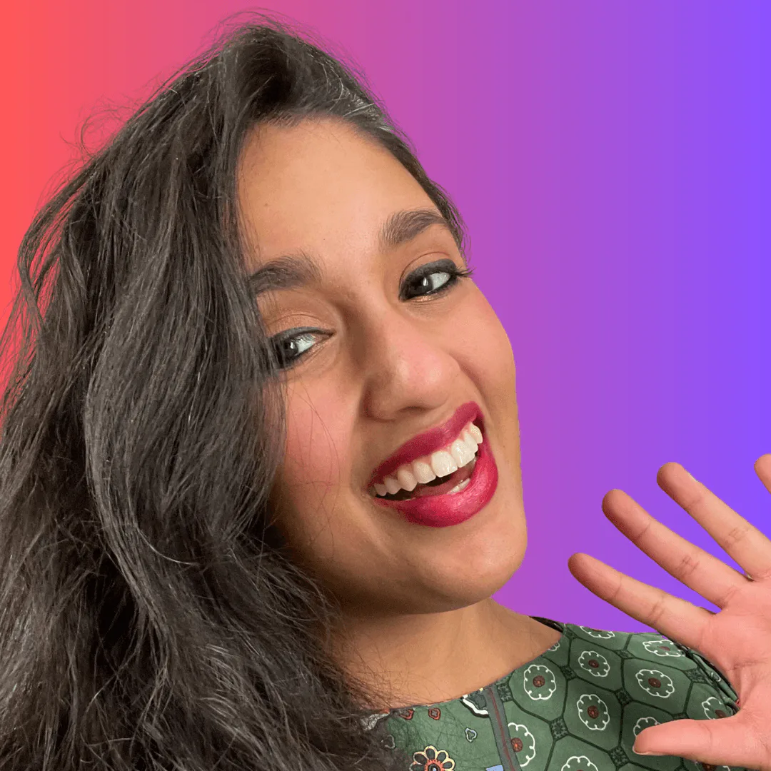 Jareen Imam smiling and waving against a red and purple background