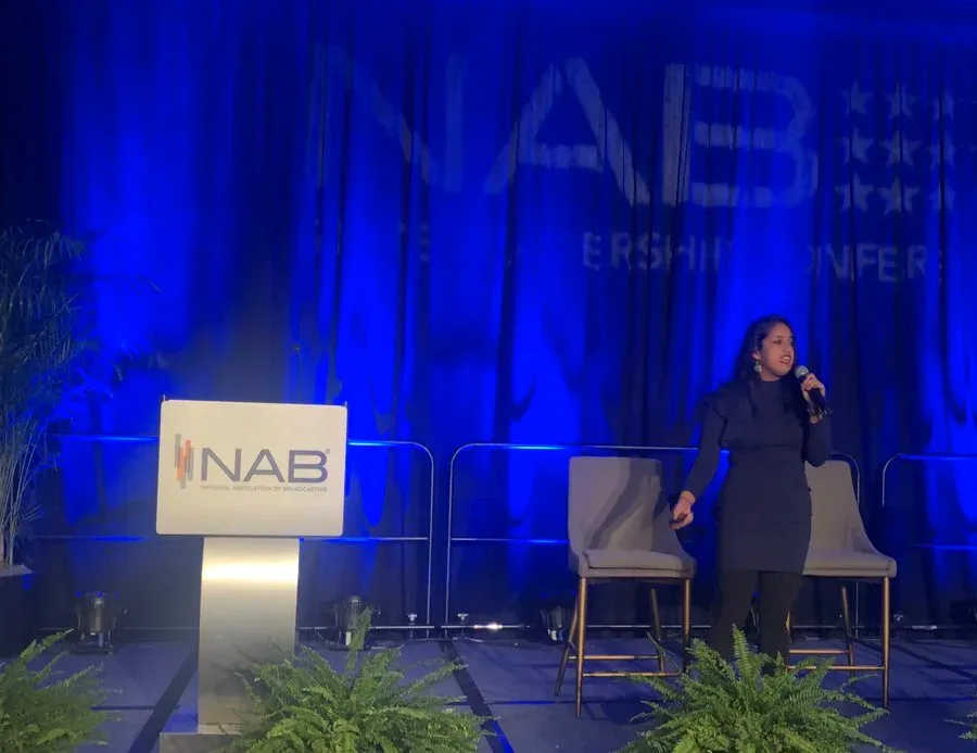 Jareen Imam speaking onstage at an NAB conference
