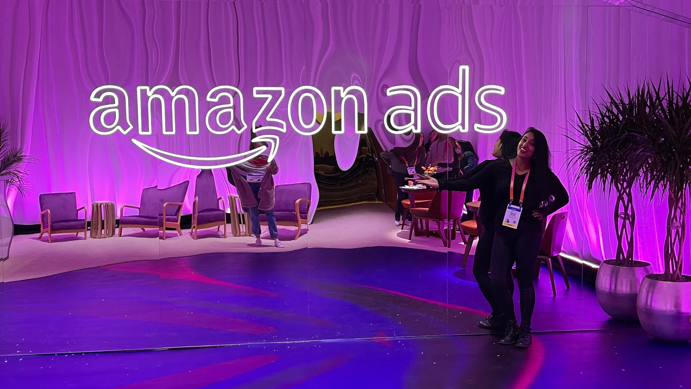 Jareen Imam stands in front of an illuminated Amazon Ads display at CES in Las Vegas.