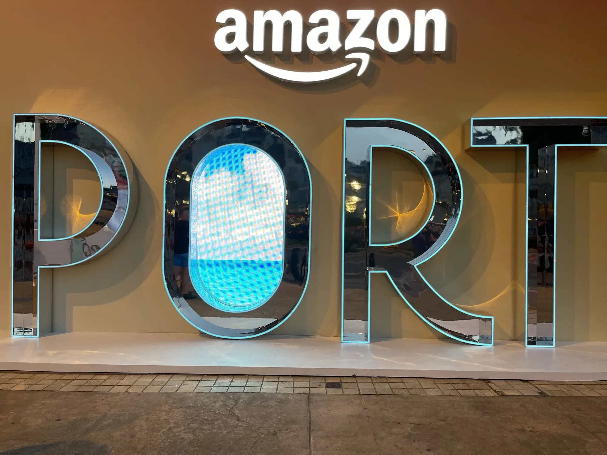 Illuminated Amazon wordmark above a large PORT installation at an Amazon event